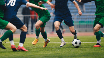 5 garçons qui jouent au football